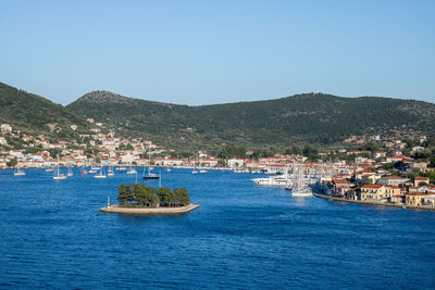 Scenic view of sea and townscape against clear blue sky