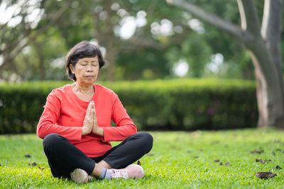 Young woman exercising on field