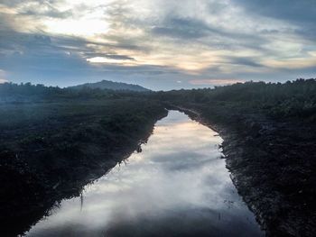 Scenic view of lake in forest against sky