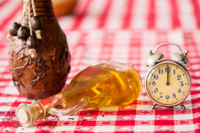 Close-up of alarm clock and container on table