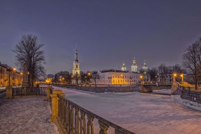 View of illuminated buildings against clear sky at night