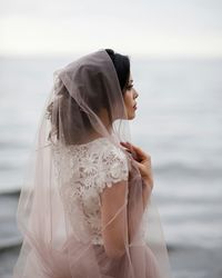 Close-up of woman with umbrella against sea
