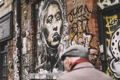 Portrait of man painting on building in city