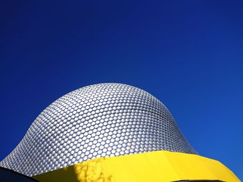 Low angle view of umbrella against clear blue sky