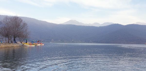 Scenic view of lake by mountains against sky