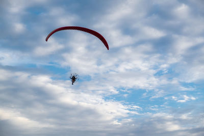 Low angle view of person paragliding against sky