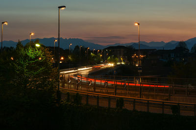 Light trails on street against sky at night