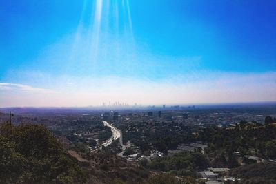 Aerial view of cityscape against blue sky