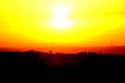 Scenic view of silhouette landscape against orange sky