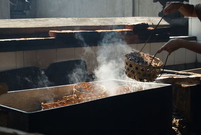 Person preparing food on barbecue grill