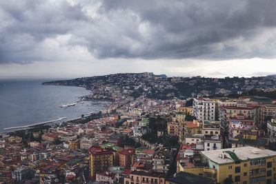 Cityscape by sea against sky