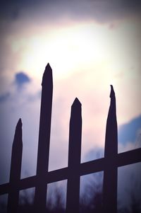 Low angle view of silhouette fence against sky during sunset