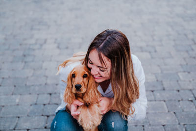 Woman with dog on footpath in city