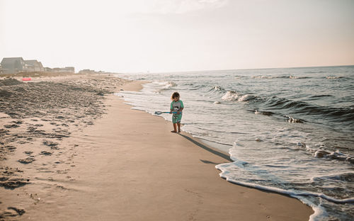 Boy on beach at sunrise