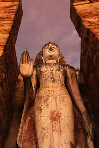 Low angle view of statue against temple against sky