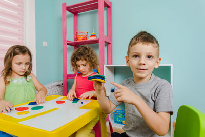 Portrait of happy friends sitting on table