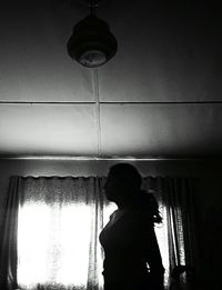 Boy standing by window at home