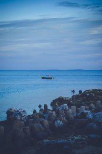 Scenic view of boat in sea against sky