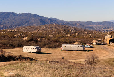 View of cars on field against mountain range