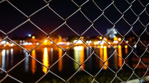 Close-up of chainlink fence at night