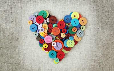Directly above shot of heart shape made with colorful buttons on table