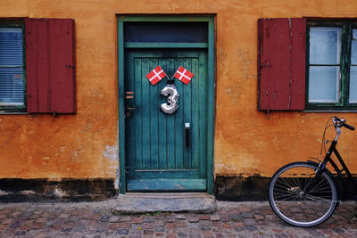 Bicycle leaning against wall of building