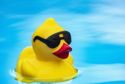 Close-up of yellow toy against blue sky