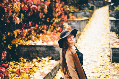 Side view of woman standing against trees