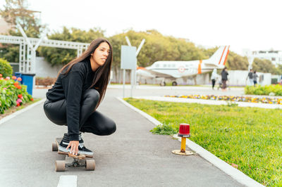 Portrait of young woman sitting on street