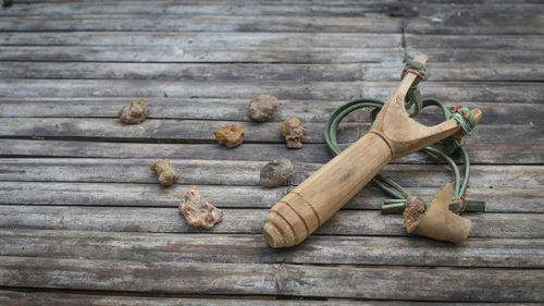 Slingshot and stones on wooden table