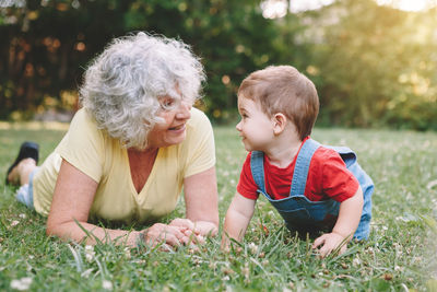 Woman and baby boy lying on grass