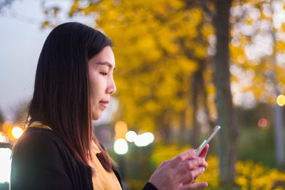 Side view of young woman looking at camera