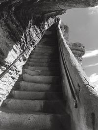 Steps leading towards sea against sky