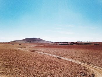 View of desert landscape against blue sky