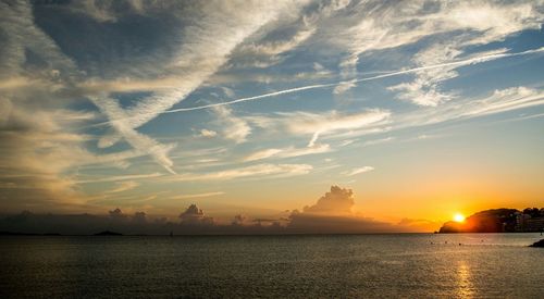 Sun shining through clouds over sea