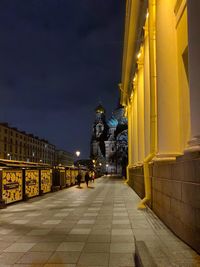 Illuminated street amidst buildings at night lamps 