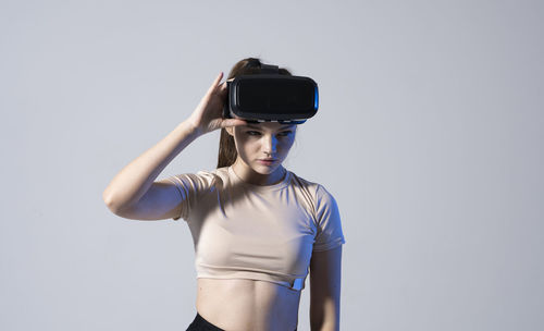 Rear view of woman holding camera against white background