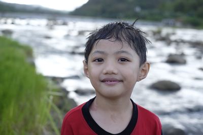 Portrait of smiling boy against river