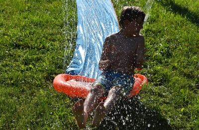 Water spraying on shirtless boy