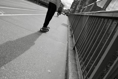 Low section of woman walking on road in city