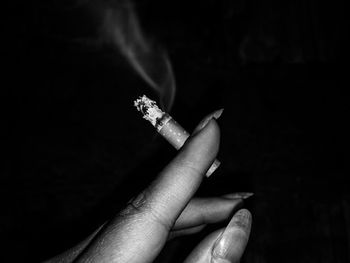 Close-up of hand holding cigarette