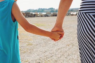 Rear view of mother and son holding hands