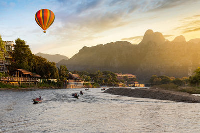 Hot air balloon flying over mountains against sky