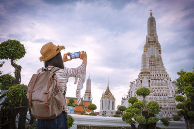 Woman photographing temple with smart phone