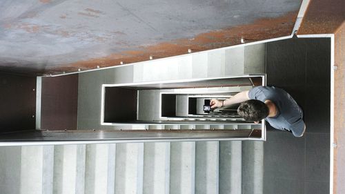 High angle view of man photographing steps in building