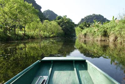 Close-up of boat in lake at forest against sky