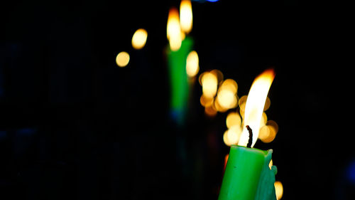 Close-up of lit candles in the dark