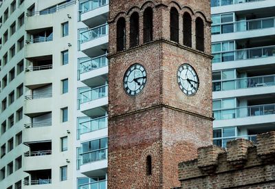 Low angle view of clock tower amidst buildings in city