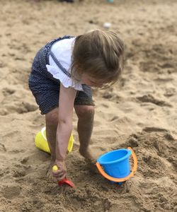 High angle view of girl playing on sand at beach