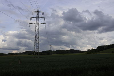 Electricity pylon on field against sky